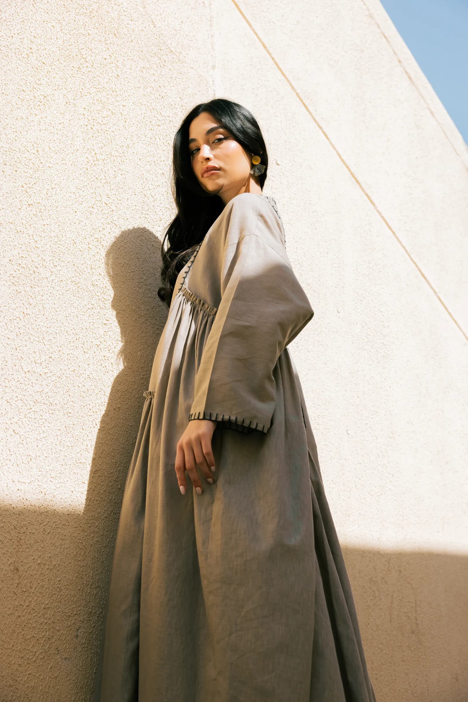 Model in an abaya posing against white walls in Kuwait