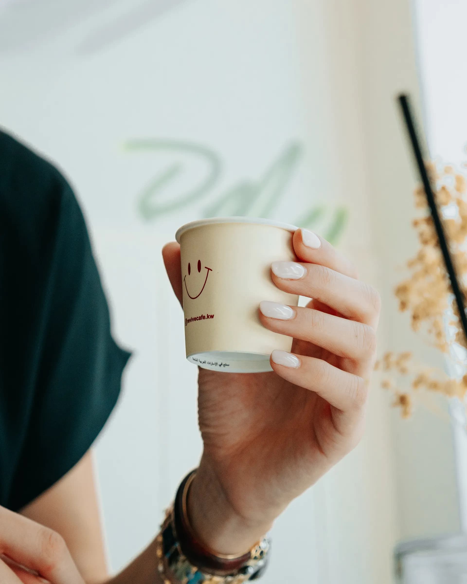 Iced latte held over denim from above